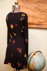 Rear view of vintage Betsey Johnson black dress, scattered yellow and pink floral print, long sleeves.