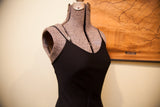 Smooth black Betsey Johnson slip gown with scoop neckline and thin strap.