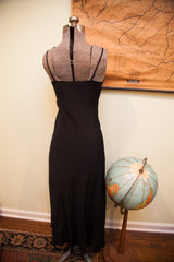 Full length back view of the simple Betsey Johnson black slip gown.