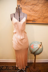 Vintage satin pink gown with V-neck and spaghetti straps, flowing silhouette.