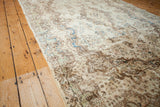 Curvilinear ivory Kerman rug motifs with soft sheen and blue and green abrash.
