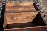 Antique wooden trunk's interior showing aged wood grain and maker's tag from 1769.