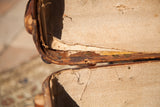 Close-up of the vintage Indestructo trunk's interior, showing frayed natural linen and aged wood.