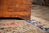 Corner of vintage cedar blanket chest, showing exposed dovetail joints and boot cut footing.