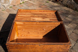Open vintage blanket chest interior, showing its light planked cedar wood.