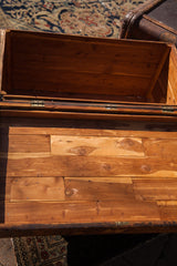 Interior view of the open vintage cedar blanket chest, revealing light wood planks.