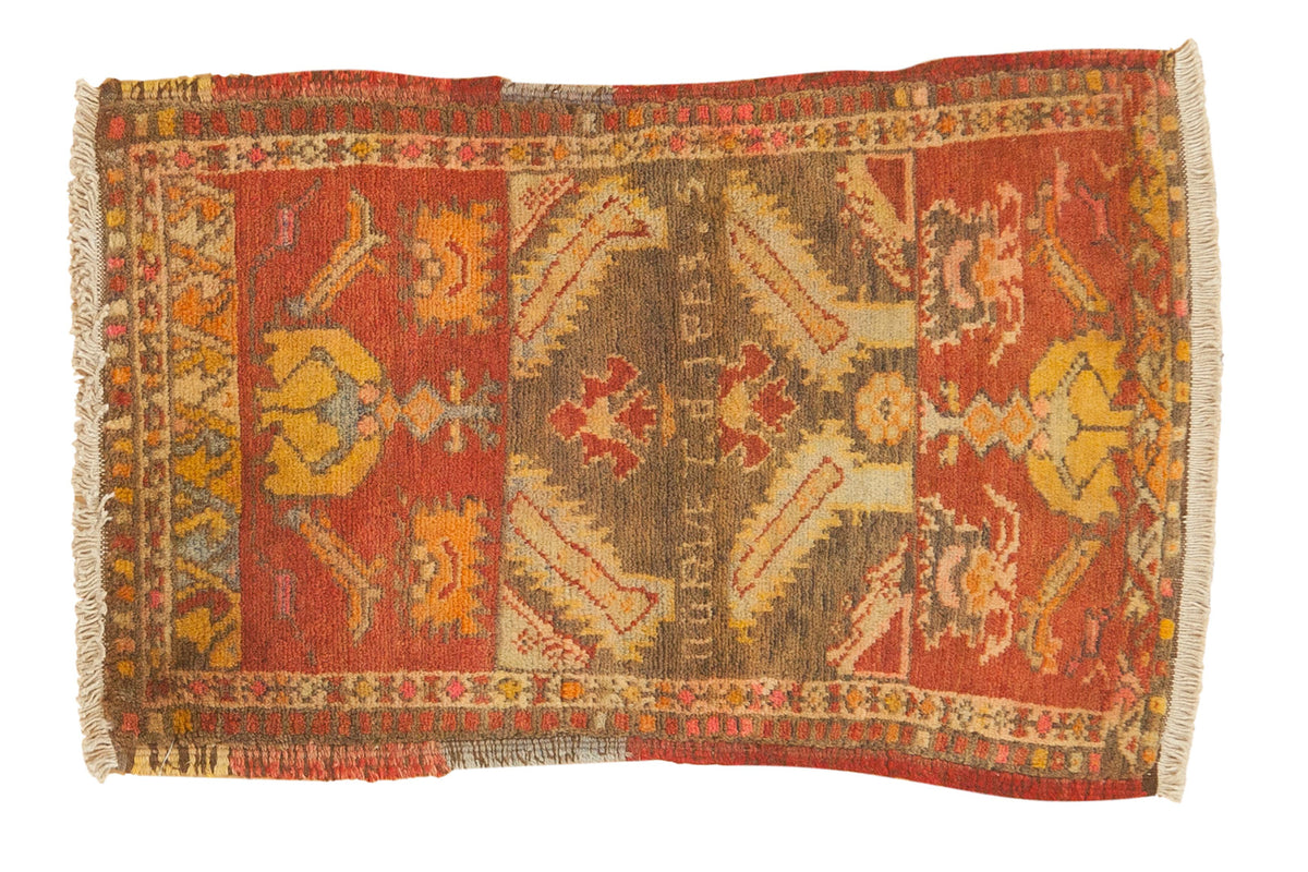Small vintage Turkish rug with asymmetric design, writing, tribal patterns in rust, brown, yellow.