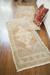Blanched Turkish rug runner's muted geometric border and intact white fringe.