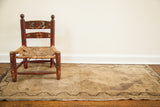 Faded field texture with dark meandering border on a vintage Turkish rug.