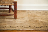 Faded pile and dark meandering border of a vintage Turkish rug runner with subtle mauve tones.