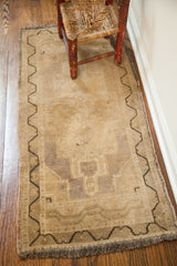 Faded vintage Turkish runner with subtle mauve hints and dark meandering geometric border.