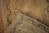 Faded vintage Turkish rug, showing back weave, dark meandering border, and intact fringe.