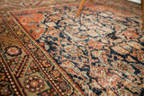 Worn Herati motif and geometric border on an antique Feraghan rug in navy and terracotta.