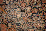 Antique Feraghan rug with worn dark blue Herati pattern detail, highlighting a historical repair.