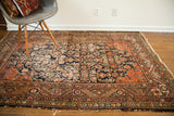 Antique Feraghan rug corner showing worn Herati motif, spandrels with intersecting lines.
