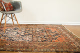 Worn Herati pattern in deep indigo and faded coral on an Antique Feraghan rug.