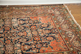 Antique Feraghan rug corner, highlighting worn Herati motif and intersecting spandrel lines.