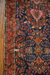 Deep blue Sarouk runner's intricate red floral patterns and tattered aesthetic detail.