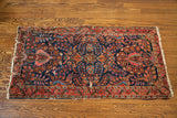 Corner detail of a vintage Deep Blue Sarouk runner with ornate floral pattern and tattered fringe.