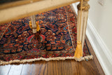 Exquisite coloration and ornate floral design on a deep blue Sarouk runner with fringe.