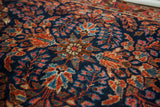 Ornate floral motifs and vibrant, time-softened hues on a vintage Sarouk rug pile.
