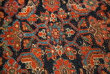 Vibrant herati design with deep blue field, red, and teal on textured Kurdish rug pile.
