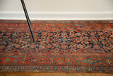 Intricate blue herati pattern on a Kurdish rug runner with visible textural wear.