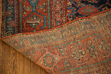 Hand-knotted vintage Kurdish runner corner revealing deep red and blue Herati design with visible foundation.