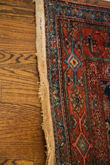 Vintage Kurdish runner: tattered side edge, exposed foundation, red and blue herati pattern.