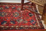 Cherry red Persian rug mat with curvilinear floral motifs and visibly faded texture.