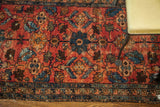 Painted Lilihan Sarouk rug displaying worn red ground and colorful stylized floral patterns.