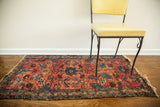 Red Lilihan Sarouk Persian rug with blue floral patterns and age-softened pile.