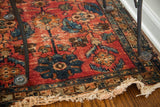 Lilihan Sarouk Persian rug corner, with distressed red field and tattered cream fringe.