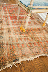 Patinaed surface of this antique rug, revealing rich abrash, faded repeating pattern, and tattered edge.