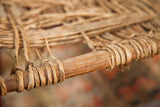 Worn rush seat hand-wrapped around the antique chair's hand-carved frame.
