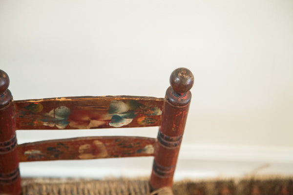 Hand-carved finial and chippy painted details on a primitive folk art chair.