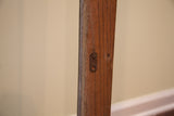 Vintage world map's original oak wood hanging, showing grain and metal bracket.