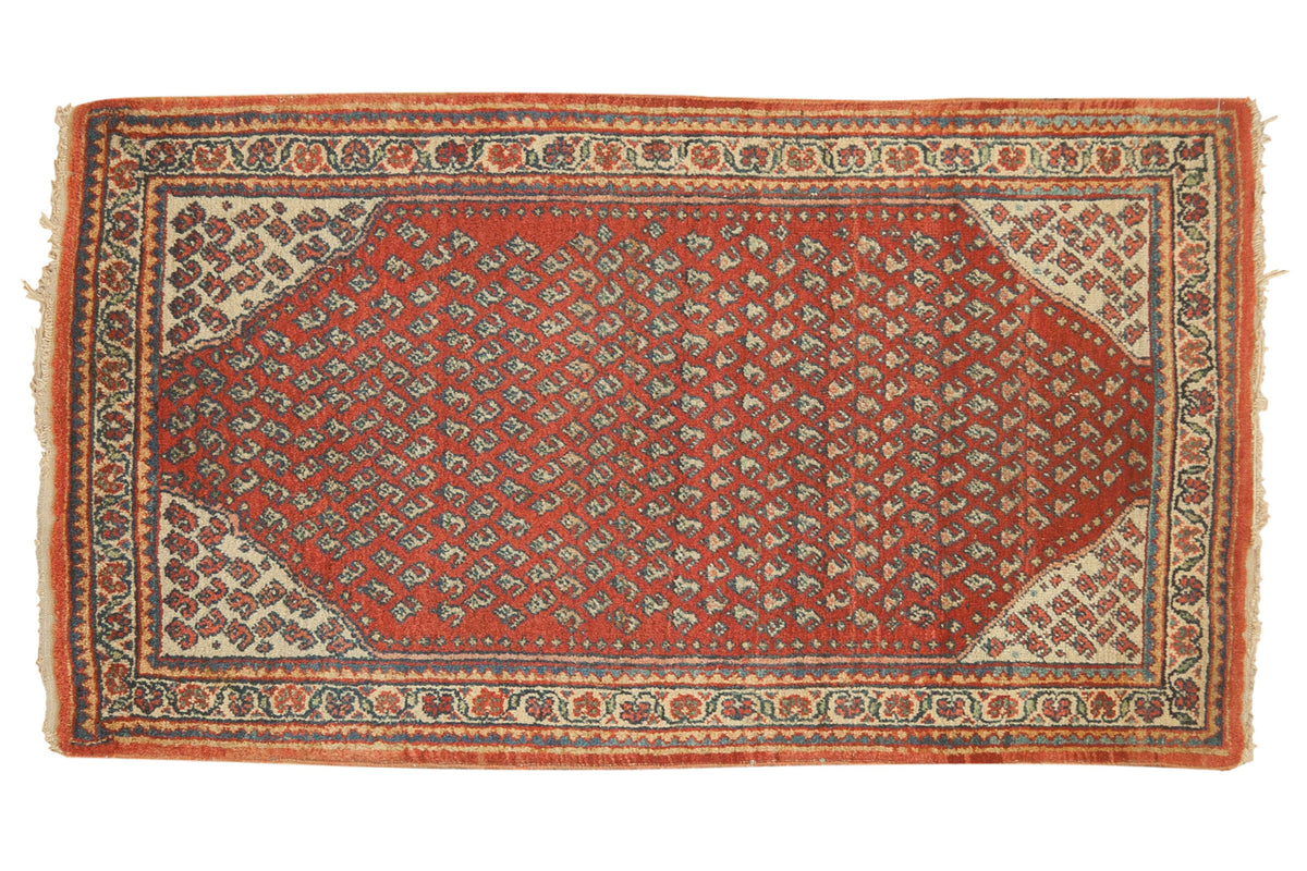 Tangerine red vintage Mir Sarouk rug with allover repeating pattern and blue, saffron accents.