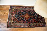Bottom right corner of the vintage indigo Lilihan rug with bold red geometric motifs.