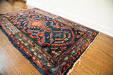 Vintage Lilihan rug in dark indigo with empowering red and orange geometric motifs.