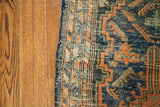Lilihan Persian rug border detail, dark indigo blue, orange, and teal geometric motifs.