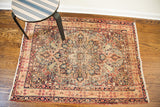 Antique Lavar Kerman rug with distressed center medallion, cypress trees, and blue-red floral patterns.