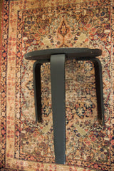Vintage Alvar Aalto design table with dark finish, curved legs, and paint chipping.