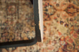 Mid Century Alvar Aalto side table edge showing black paint chipping and wear.