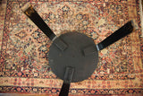 Mid Century Alvar Aalto table underside with black tripod base and central pinhole.