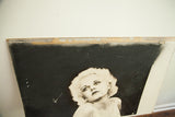 Detail of the vintage Jean Harlow street art's top edge, showing peeling and cosmetic wear.