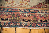 Whimsical rose, teal, and beige patterned borders of an antique Laver Kerman rug.