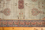 Whimsical red and pink floral motifs on antique Laver Kerman rug's seafoam field.