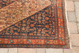 Antique Persian Senneh rug corner with herati motif, red border, and unusual purple silk selvage.