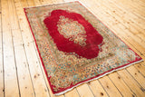 Detail of Cyrus Crown Kerman rug, featuring ivory floral border and rich cochineal red field.